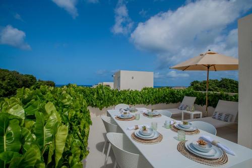 a white table with chairs and an umbrella on a patio at Garden Grove in Saint James