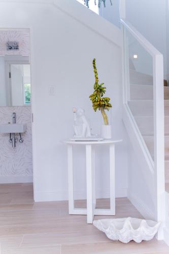 a white table in a hallway with a plant on it at Garden Grove in Saint James