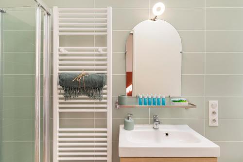 une salle de bain avec un lavabo et un miroir dans l'établissement Cosy and Trendy 3 Bedrooms train tramway, à Nice