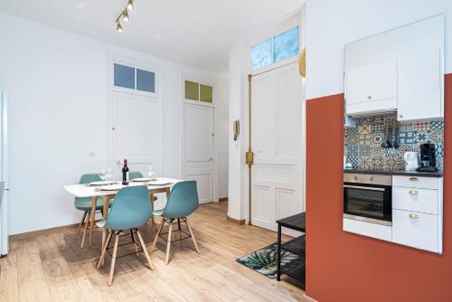 une cuisine et une salle à manger avec une table et des chaises dans l'établissement Cosy and Trendy 3 Bedrooms train tramway, à Nice
