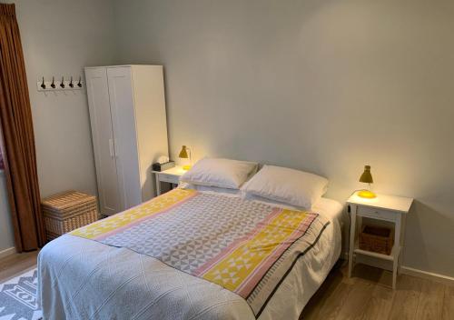 a bedroom with a bed with two tables and two lamps at Waddenhoes Gastenverblijven in Pieterburen