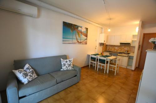 sala de estar con sofá, mesa y cocina en Lignano, en Lignano Sabbiadoro