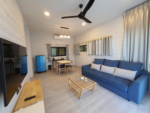 a living room with a blue couch and a table at Villa PaSon in Khao Kho
