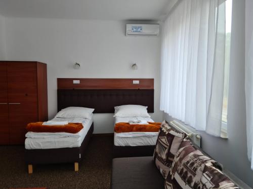 a bedroom with two beds and a couch at "Hel" Wieniec Zdrój in Włocławek
