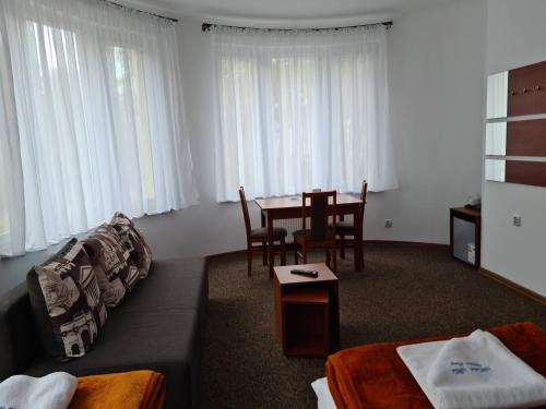 a living room with a table and a couch at "Hel" Wieniec Zdrój in Włocławek
