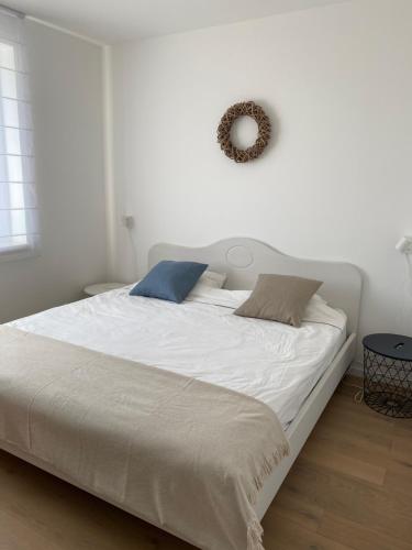 a white bed with two pillows on top of it at OpusTisza7 Apartman in Tiszafüred