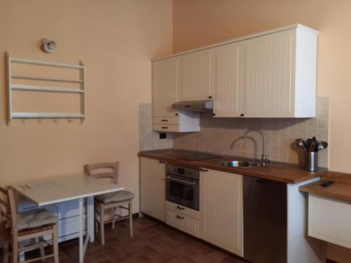 a kitchen with white cabinets and a sink and a table at Cascina Battivacco in Milan