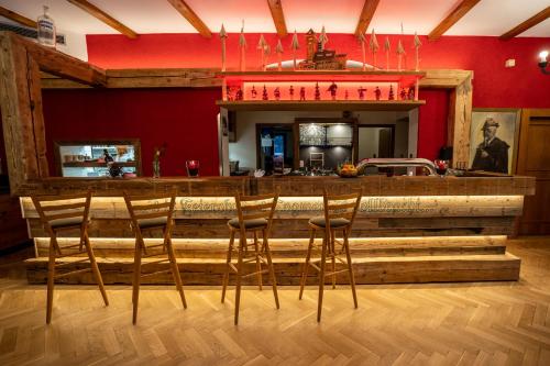 a bar with wooden stools in a restaurant at Berghotel Bärenstein in Bärenstein