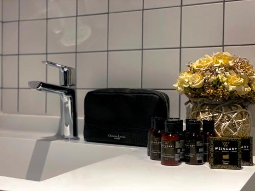 a bathroom counter with a sink with a toaster and cosmetics at Weingart Istanbul in Istanbul