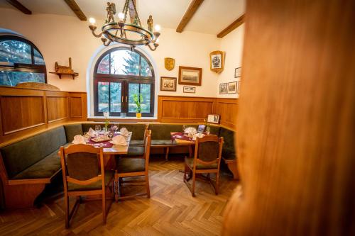 a dining room with a table and chairs and a window at Berghotel Bärenstein in Bärenstein