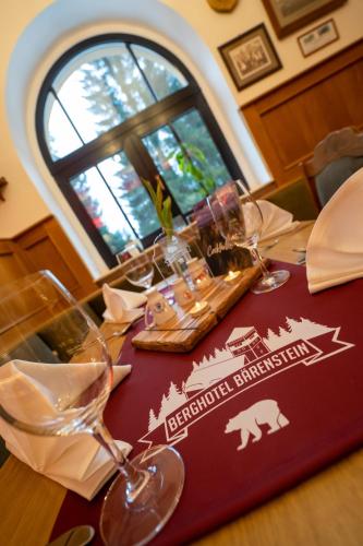 a table with wine glasses on top of it at Berghotel Bärenstein in Bärenstein