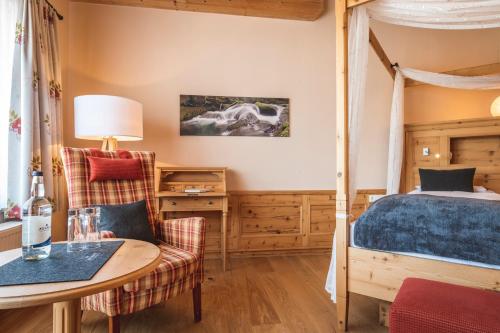 a bedroom with a bed and a table and chairs at Hotel Natur-Landhaus Krone in Maierhöfen
