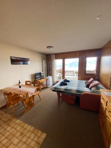 a bedroom with a bed and a table and chairs at Studios Bellevue 1 et 2, ski lift 150m in Veysonnaz