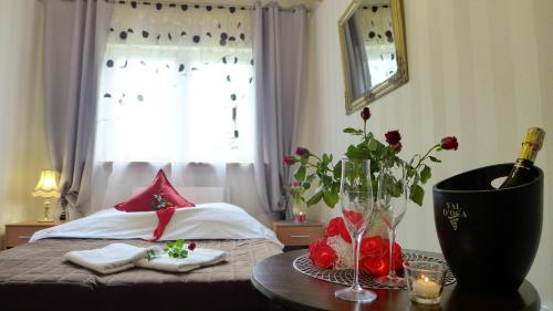 a bedroom with a bed and a table with flowers on it at Wrzos & Belvedere in Kudowa-Zdrój