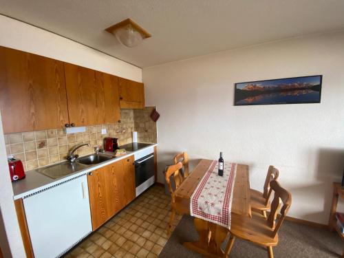 a kitchen with a wooden table and a sink at Studios Bellevue 1 et 2, ski lift 150m in Veysonnaz