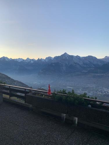a bench on the side of a mountain with a view at Studios Bellevue 1 et 2, ski lift 150m in Veysonnaz