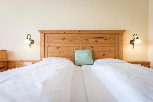 a bedroom with two white beds with a blue pillow at Hotel Natur-Landhaus Krone in Maierhöfen