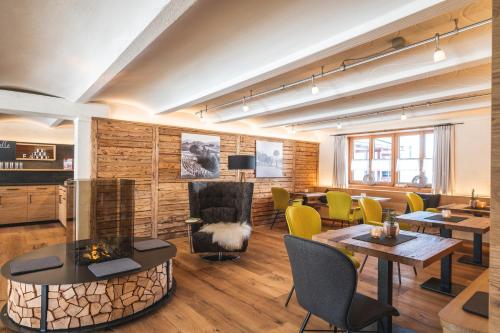 a living room with tables and chairs and a fireplace at Hotel Natur-Landhaus Krone in Maierhöfen
