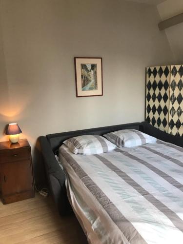 une chambre avec un lit et une table avec une lampe dans l'établissement Villa Castelet, à Dinard