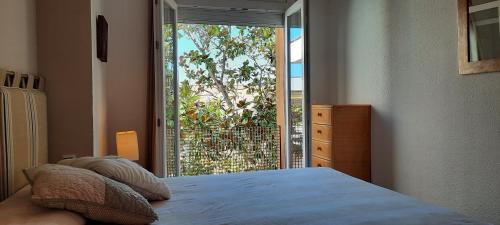 a bedroom with a bed and a sliding glass door at Apartamento de standing Calella de Palafrugell in Calella de Palafrugell
