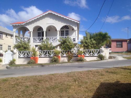 a white house on the side of a street at Sea Shells Villa in Christ Church
