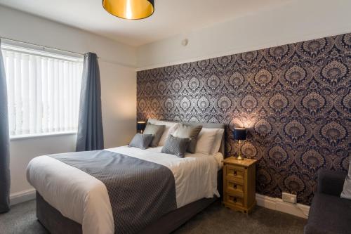 1 dormitorio con 1 cama grande y pared en The Fountaindale Skegness, en Skegness