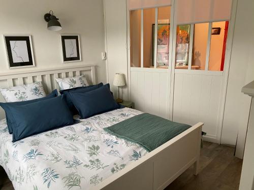 a bedroom with a bed with blue and green pillows at Cottage familial avec jardin - 200m de la plage in Yport