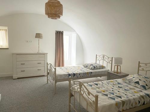 une chambre avec deux lits et une commode dans l'établissement Appartement F2 Duplex, à Sartène