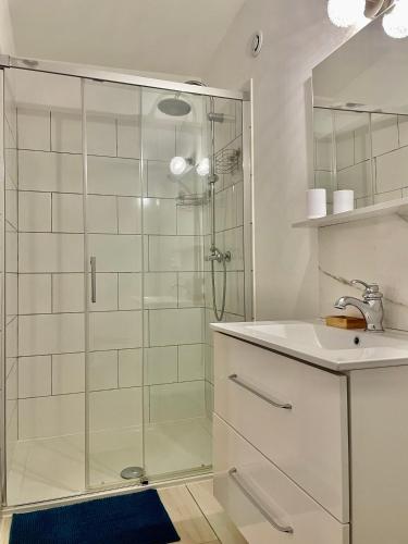 y baño con ducha acristalada y lavamanos. en Appartement F2 Duplex en Sartène