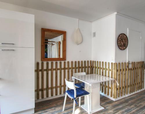 ein Esszimmer mit einem weißen Tisch und einem blauen Stuhl in der Unterkunft Appartement Plage et JACUZZI Balnéothérapie Athis Mons in Athis-Mons