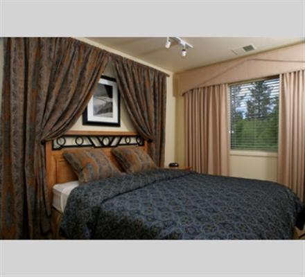 um quarto com uma cama e uma janela com cortinas em GetAways at the Lodge at Kingsbury Crossing em Stateline