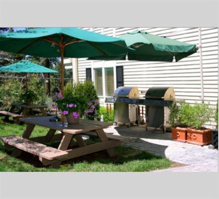 a picnic table with a green umbrella and a grill at GetAways at the Lodge at Kingsbury Crossing in Stateline