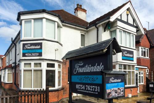 a white house with a sign in front of it at The Fountaindale Skegness in Skegness