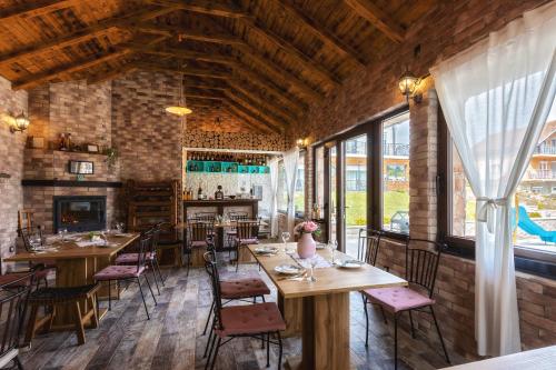 un ristorante con tavoli e sedie in legno e finestre di Villa Waterfalls Plitvice a Rakovica