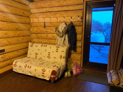 スーズダリにあるГостевой дом У Ольгиのログキャビン内のベッド1台が備わる客室です。