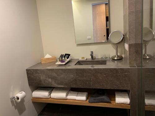 y baño con lavabo, espejo y toallas. en Hotel México Plaza Querétaro, en Querétaro