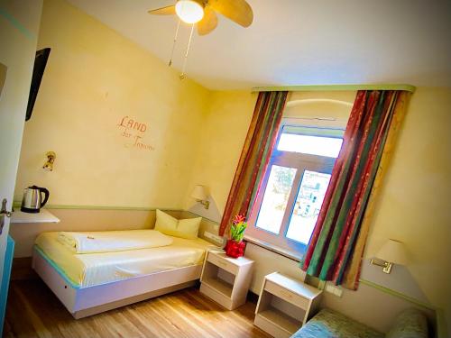 a small bedroom with a bed and a window at Meister BÄR HOTEL Fichtelgebirge in Marktredwitz