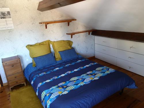 a bedroom with a bed with blue sheets and yellow pillows at MAISON DE CARACTERE POUR 6 PERS AVEC PISCINE in Agde