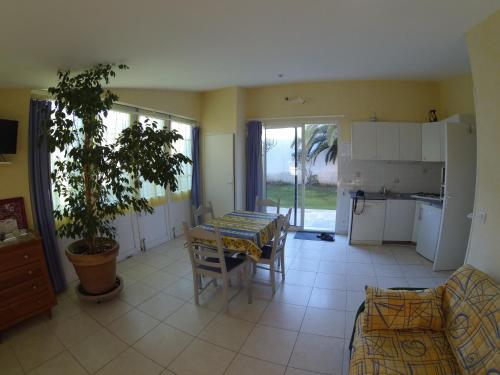 un salon avec une table et une cuisine dans l'établissement GITE MEUBLE POUR 1,2,3,4 PERS AVEC PISCINE à PARTAGER, à Agde