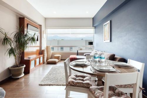 a dining room with a table and chairs in a living room at Parque Sur Beautiful apartment 2 BE - 2 BA - 2 Parkings in Mexico City