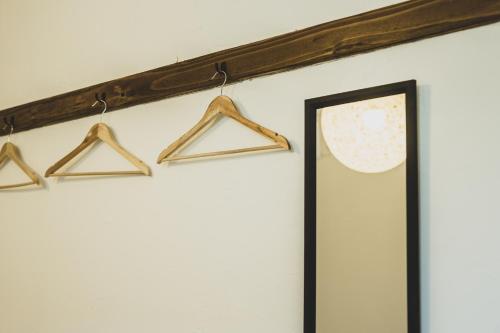 a row of hangers on a wall next to a door at Otaru Tap Room & Hostel in Otaru