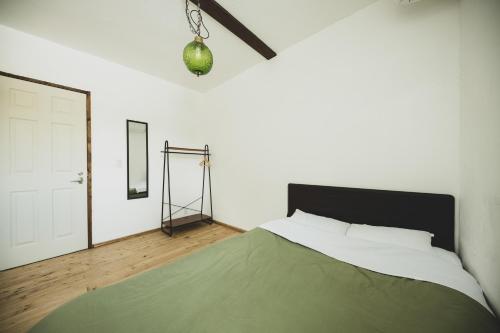 a bedroom with a large bed and a mirror at Otaru Tap Room & Hostel in Otaru