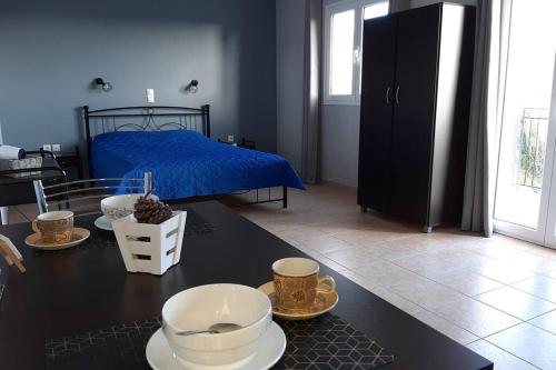 Un dormitorio con una cama y una mesa con platos y tazas. en Rodanthy III en Katelios