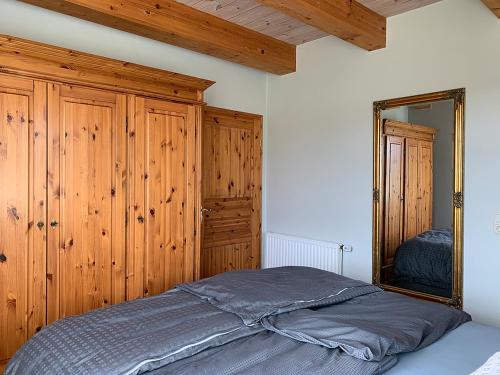 a bedroom with a bed and a mirror at Abendstille, Ferienwohnung für maximal 4 Erwachsene und 2 Kinder in DE FEERJENHUSEN am Haubarg von Vollerwiek in Vollerwiek