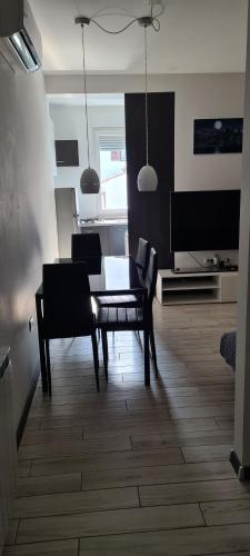 a living room with a table and chairs and a television at Apartments Peti in Pula