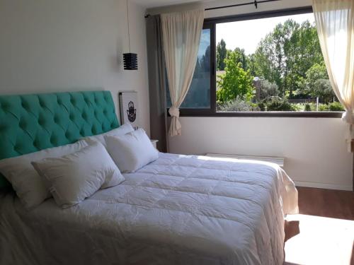 a bedroom with a large bed with a large window at Olivos de Terrada in Ciudad Lujan de Cuyo