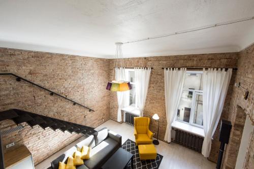 a living room with a couch and yellow chairs at Stylish Studio Apartment in the Heart of Riga in Riga