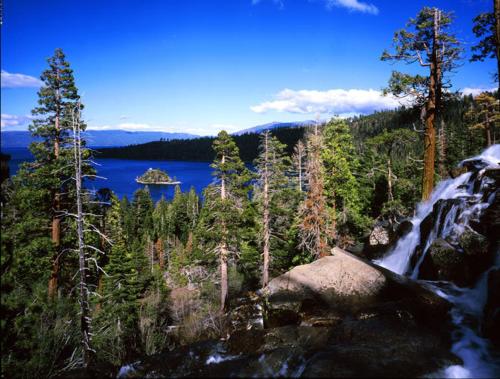 a waterfall in the middle of a forest next to a lake at GetAways at the Lodge at Kingsbury Crossing in Stateline