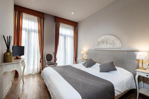 a hotel room with a large bed and windows at Hotel Marconi in Sirmione