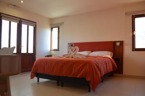 a bedroom with a bed with a red blanket at La Chakana Humahuaca in Humahuaca